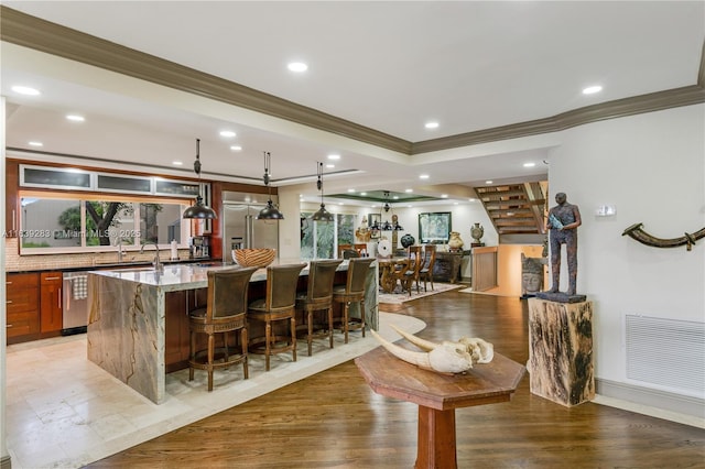 bar featuring light wood-type flooring, wet bar, visible vents, and recessed lighting