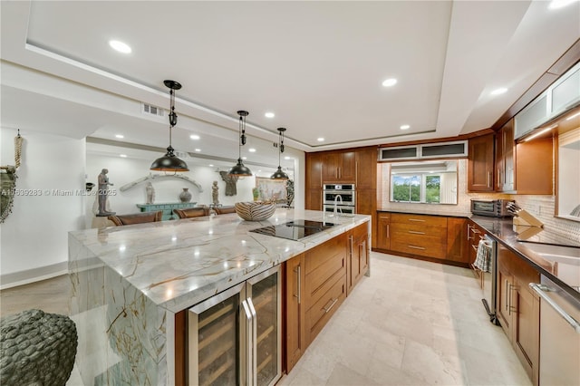 kitchen with light stone counters, wine cooler, stainless steel appliances, a spacious island, and decorative backsplash