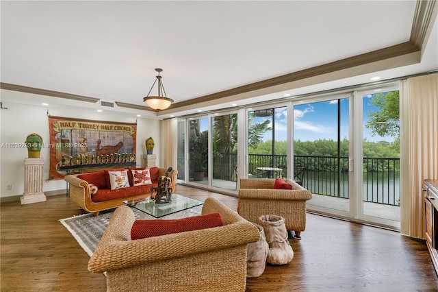 living room with visible vents, a raised ceiling, wood finished floors, crown molding, and floor to ceiling windows