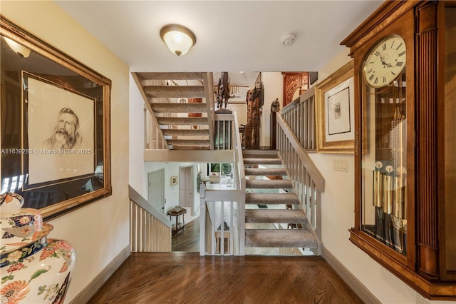 stairs with wood finished floors and baseboards