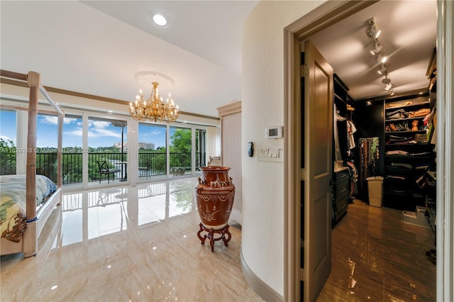 hallway featuring an inviting chandelier and track lighting