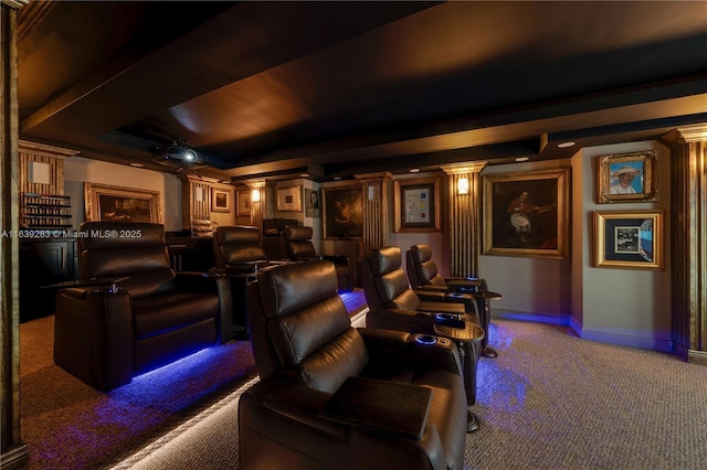 cinema room with carpet floors, ornate columns, baseboards, and a tray ceiling