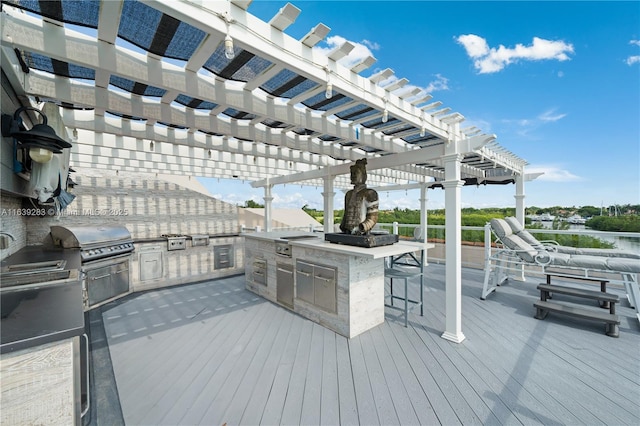 wooden deck with an outdoor kitchen, area for grilling, and a pergola