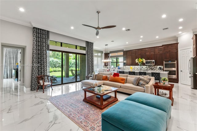 living room with ornamental molding, ceiling fan, and a healthy amount of sunlight