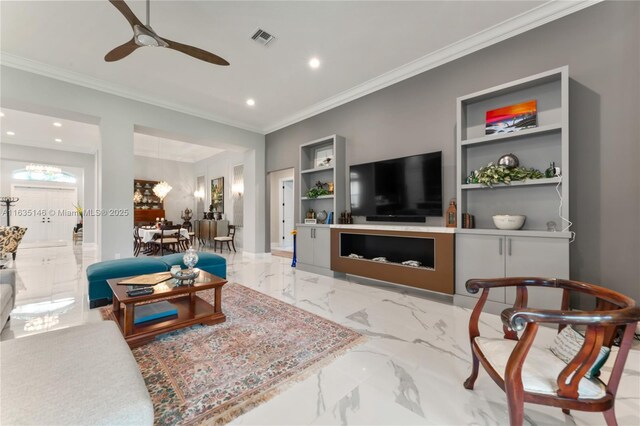 living room with built in shelves, ceiling fan, and crown molding