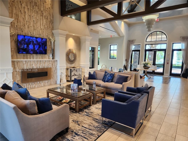 tiled living room featuring a fireplace, french doors, an inviting chandelier, and high vaulted ceiling