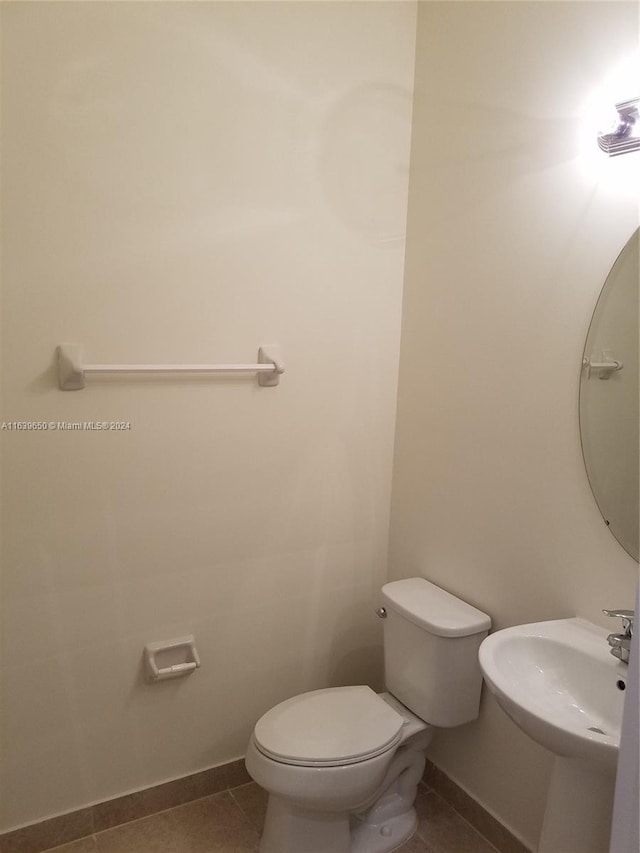 bathroom with sink, toilet, and tile patterned flooring