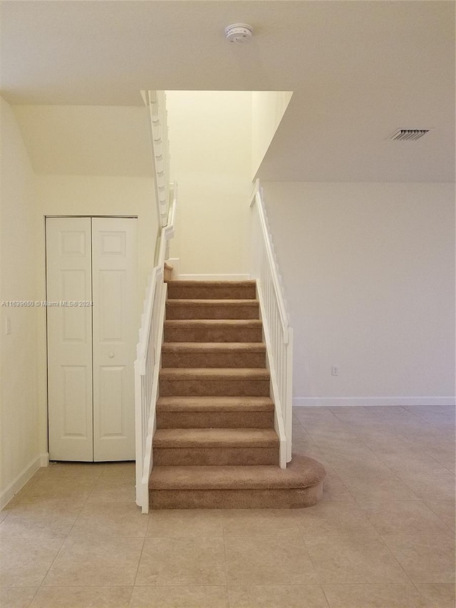 staircase featuring tile patterned floors