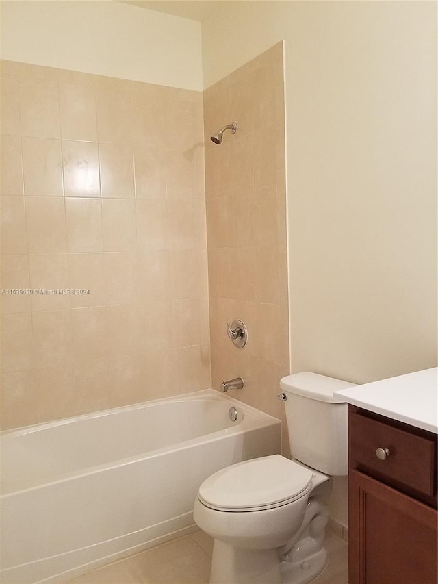 full bathroom featuring tile patterned floors, vanity, tiled shower / bath, and toilet