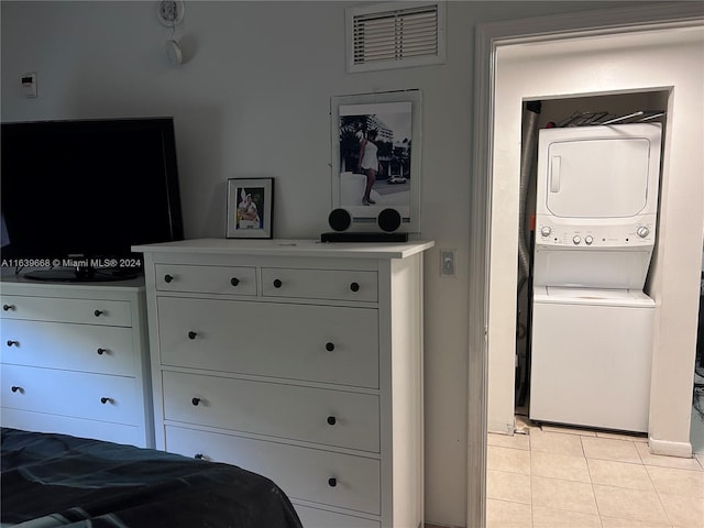 bedroom with stacked washer and dryer and light tile patterned flooring