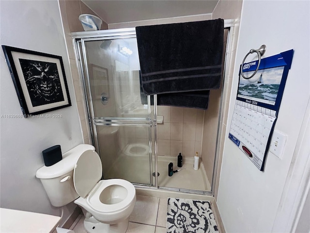 bathroom with walk in shower, toilet, and tile patterned floors