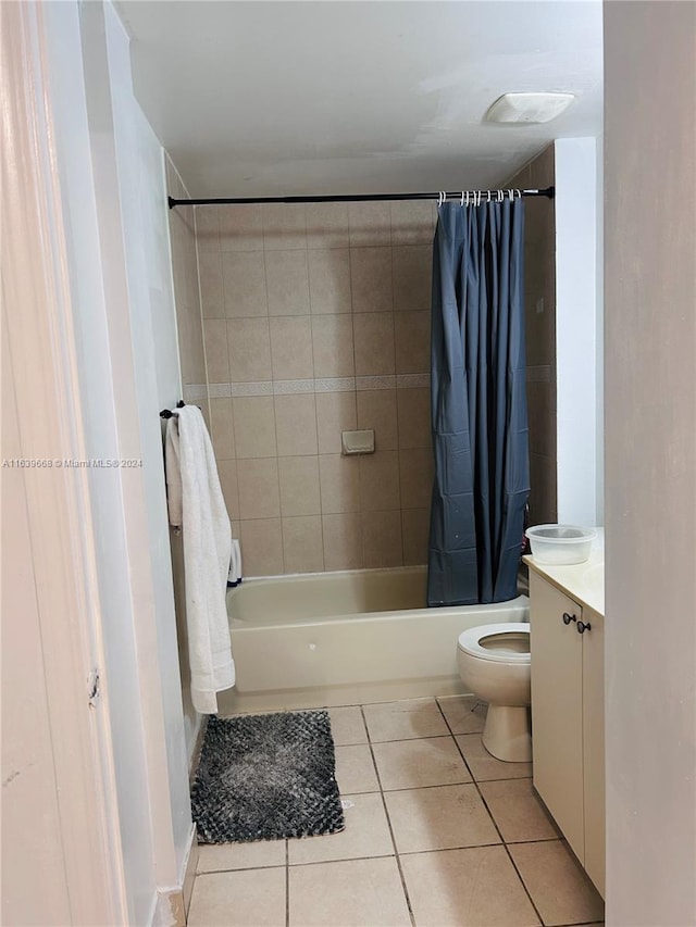 full bathroom featuring toilet, vanity, tile patterned floors, and shower / tub combo with curtain