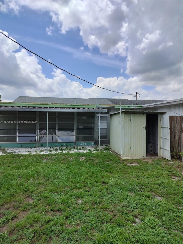 back of property with a sunroom and a yard