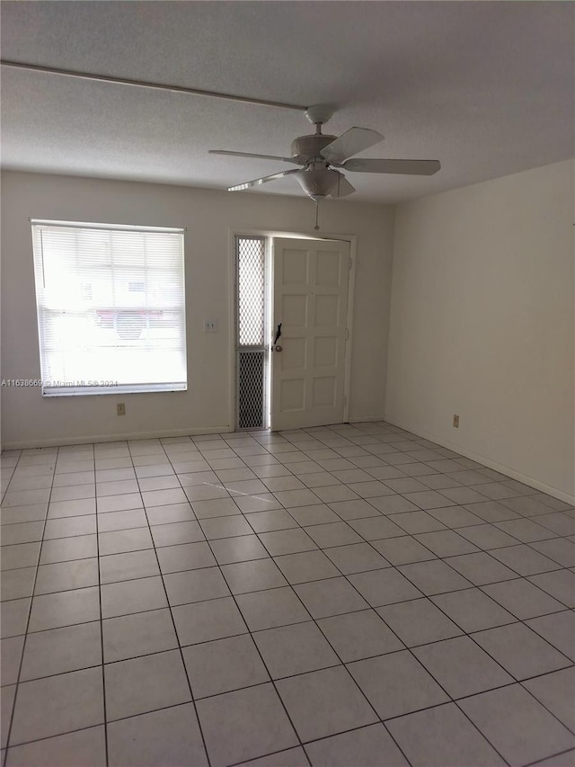 tiled empty room with ceiling fan