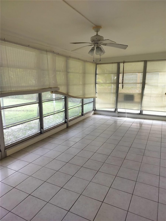 unfurnished sunroom with ceiling fan