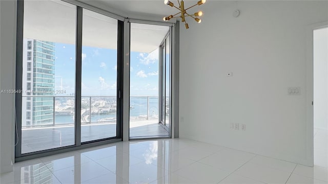 empty room featuring light tile patterned floors, a wall of windows, plenty of natural light, and a water view