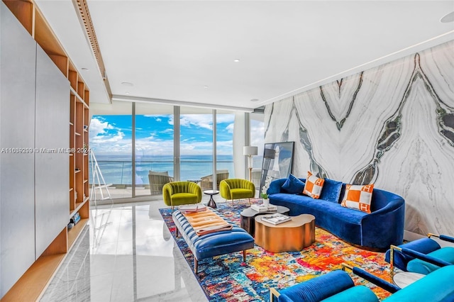 living room with light tile patterned floors, a water view, and floor to ceiling windows