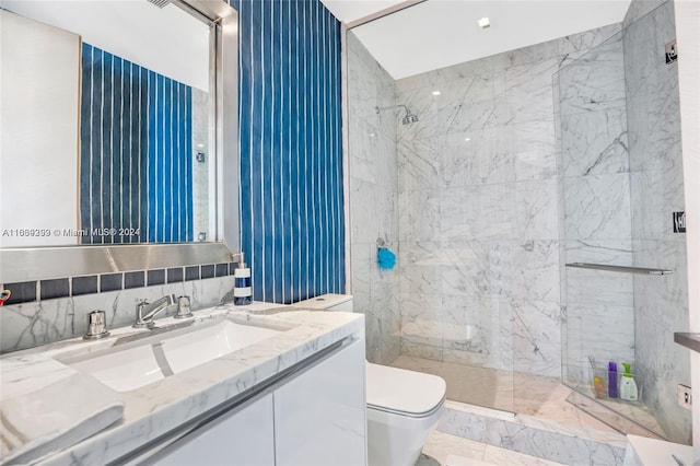 bathroom featuring tile walls, toilet, a tile shower, vanity, and tile patterned flooring