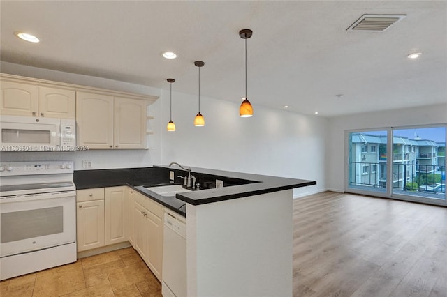 kitchen with sink, white appliances, hanging light fixtures, and kitchen peninsula