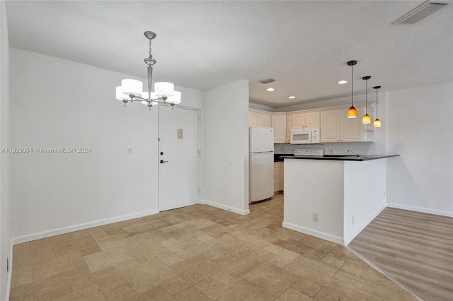 kitchen with hanging light fixtures, white appliances, kitchen peninsula, and a chandelier