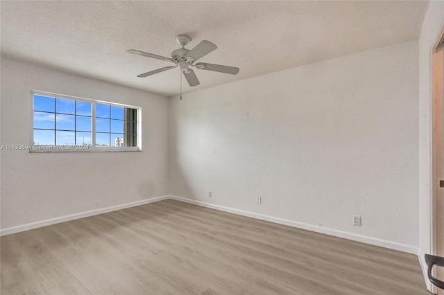 empty room with ceiling fan, hardwood / wood-style flooring, and a textured ceiling