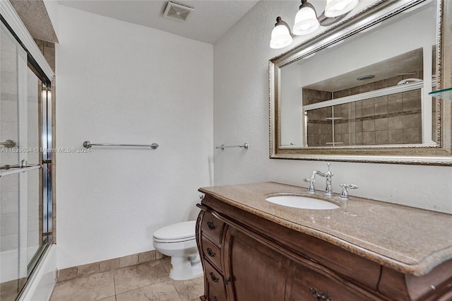 full bathroom featuring shower / bath combination with glass door, vanity, toilet, and tile patterned flooring