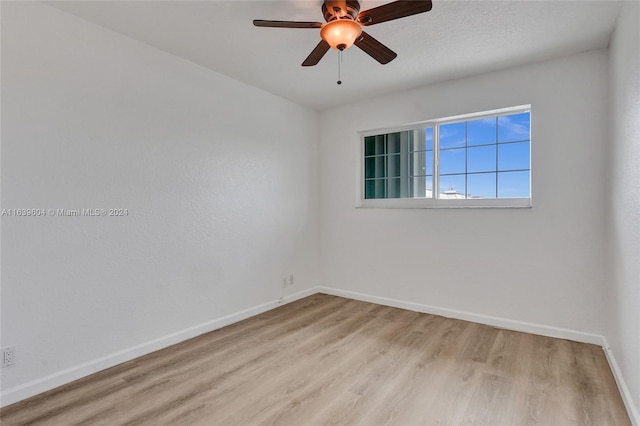 spare room with ceiling fan and light wood-type flooring