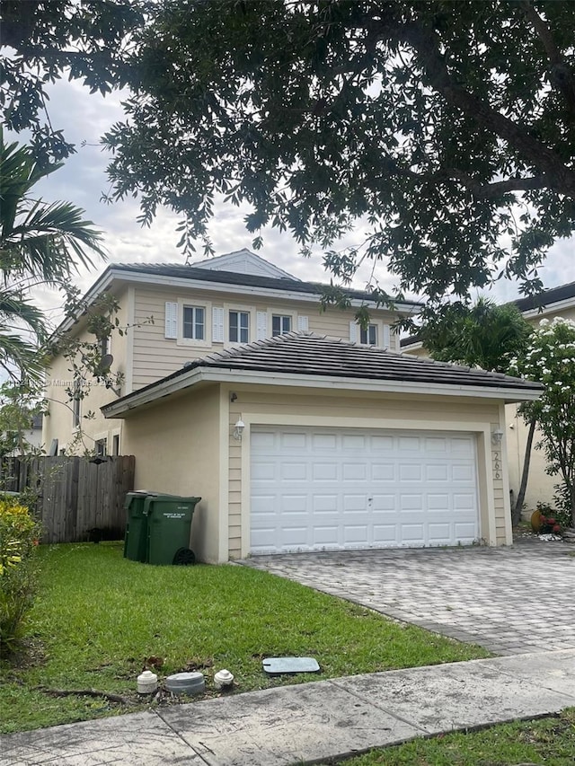 view of front of property featuring a garage and a front lawn