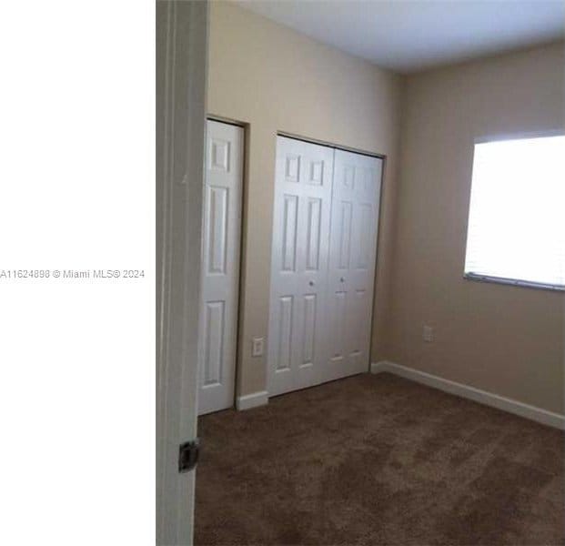 unfurnished bedroom with multiple closets and carpet floors