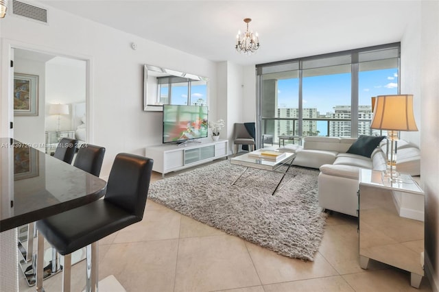 tiled living room featuring a wall of windows and a notable chandelier