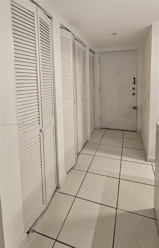 hall with light tile patterned floors