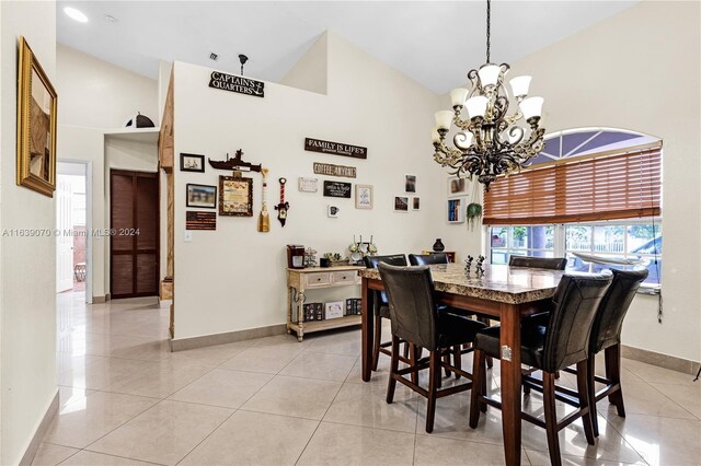 tiled dining area with a notable chandelier and high vaulted ceiling