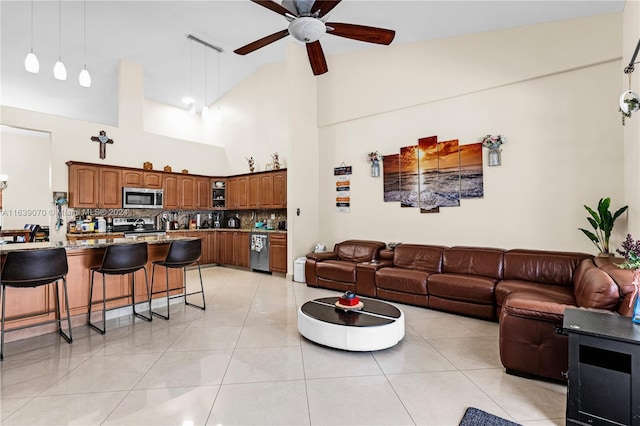 living room featuring ceiling fan, high vaulted ceiling, and light tile patterned flooring