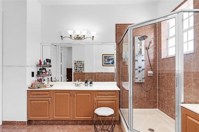 bathroom featuring a shower with shower door, vanity, and tile patterned flooring