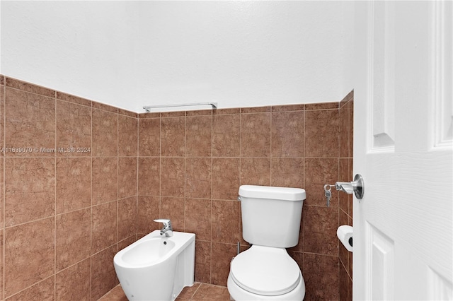 bathroom featuring tile walls, toilet, tile patterned floors, and a bidet