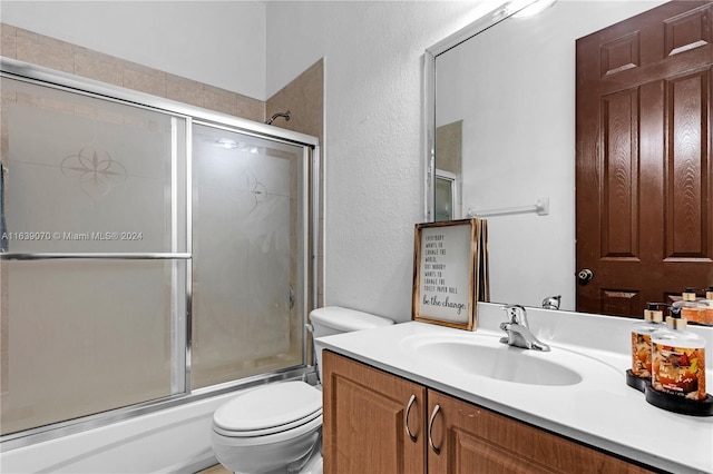 full bathroom with vanity, toilet, and shower / bath combination with glass door