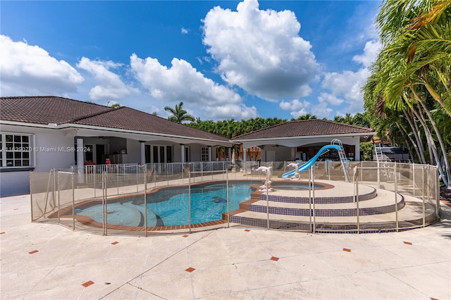 view of pool featuring a water slide and a patio area