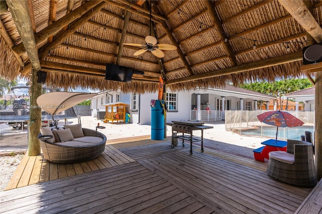 deck with ceiling fan, a swimming pool, and a gazebo