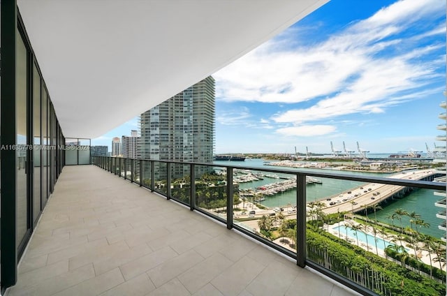 balcony featuring a water view and a city view