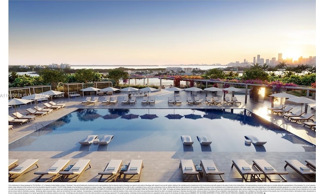 pool at dusk featuring a city view