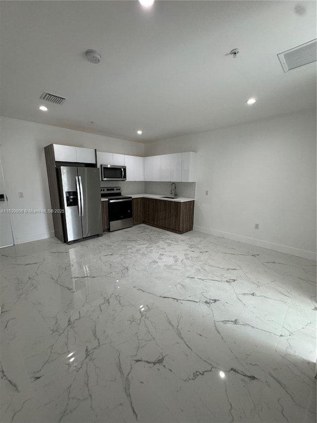 kitchen with sink, white cabinetry, and stainless steel appliances