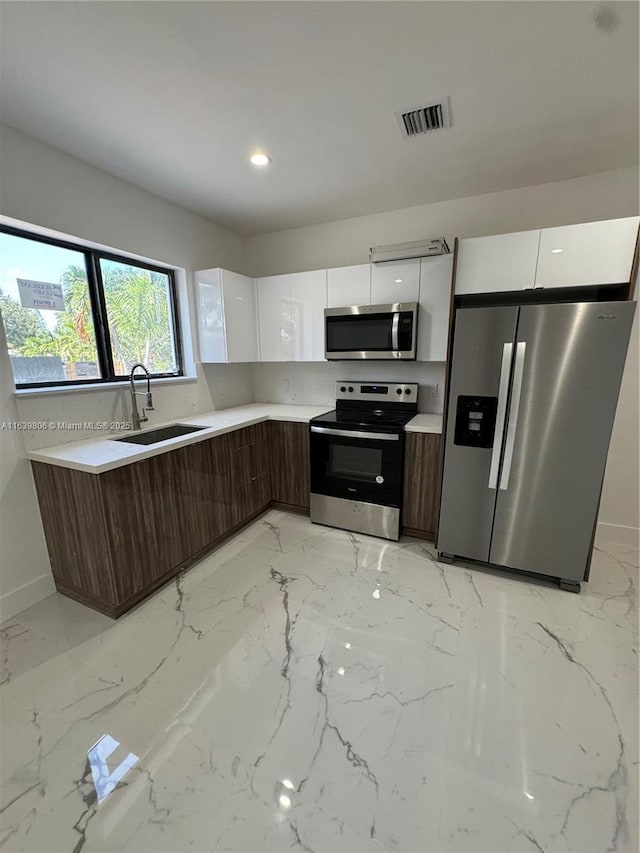 kitchen featuring sink, dark brown cabinetry, white cabinets, and stainless steel appliances