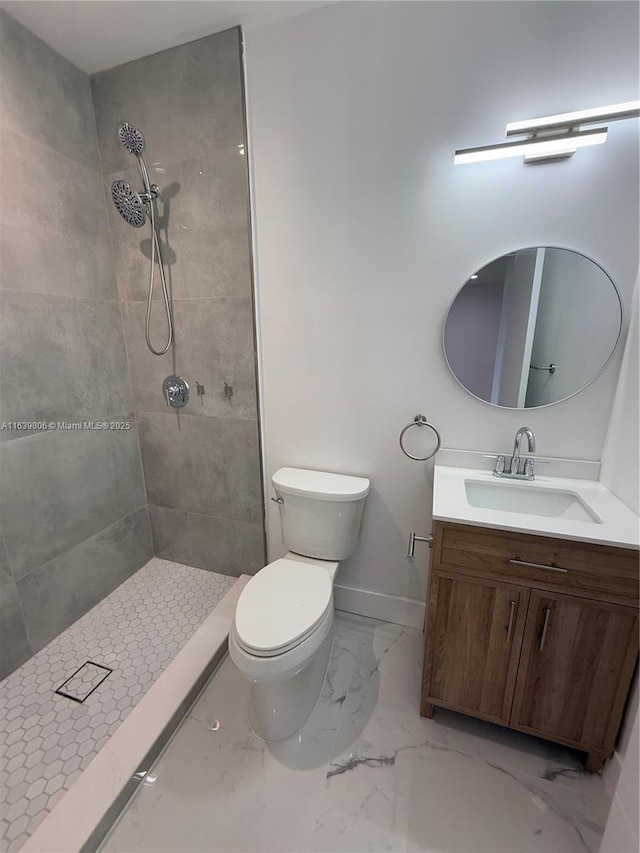 bathroom featuring vanity, toilet, and tiled shower