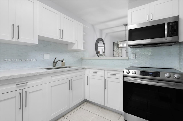 kitchen featuring appliances with stainless steel finishes, light tile patterned floors, decorative backsplash, and white cabinetry