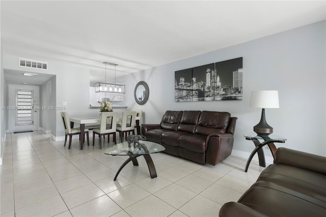 tiled living room featuring a chandelier