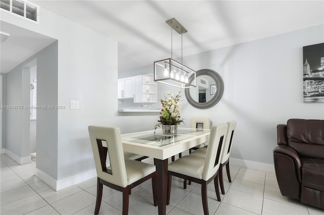 dining area with light tile patterned floors and a chandelier