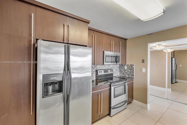 kitchen featuring tasteful backsplash, stainless steel appliances, and light tile patterned flooring