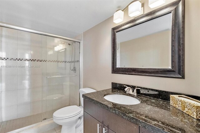 bathroom featuring vanity, toilet, and walk in shower