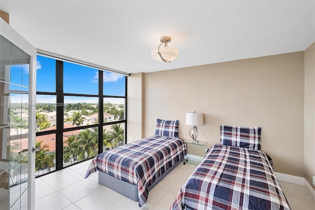 bedroom featuring floor to ceiling windows and light tile patterned floors