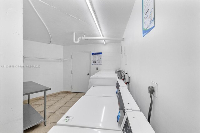 washroom with light tile patterned floors and washing machine and clothes dryer